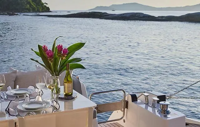 Slide: The Image of Luxurious Schaefer 660 yacht dining setup with ocean view, flowers, and wine, 2025 model. - 37