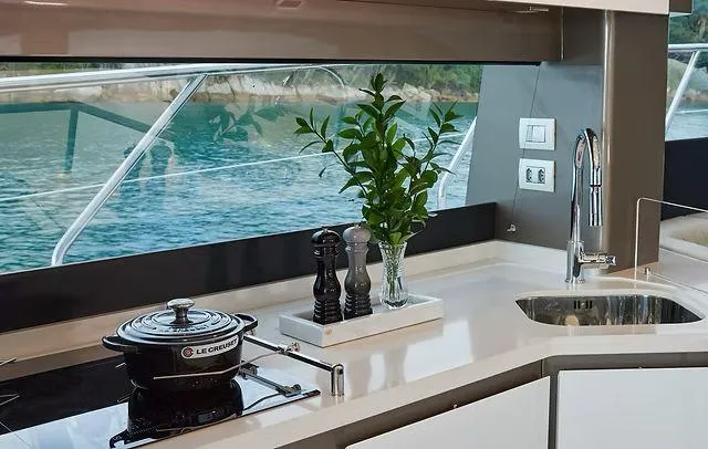 Slide: The Image of Modern yacht kitchen interior with sleek design, featuring a Le Creuset pot and scenic ocean view. - 8