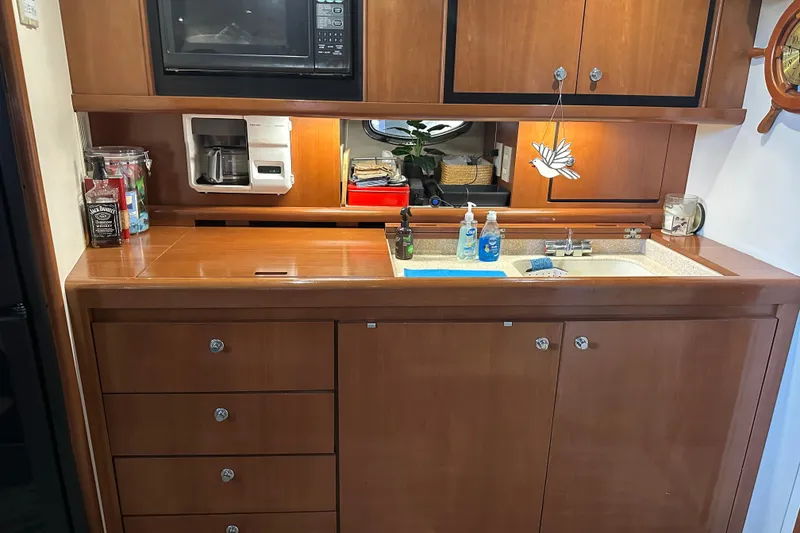 Slide: The Image of 1998 Trojan 440 Express yacht kitchen with wooden cabinets, sink, and appliances. - 11