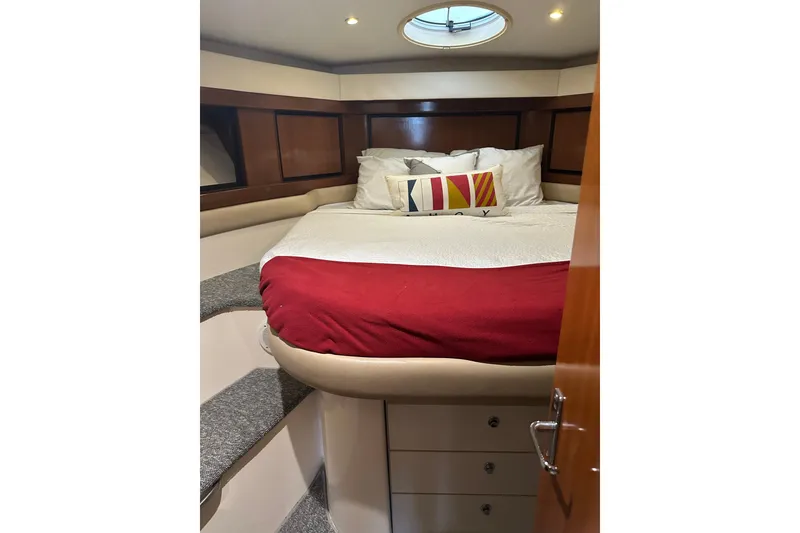 Slide: The Image of Cozy cabin bedroom in 1998 Trojan 440 Express yacht with red bedding and decorative pillows. - 16