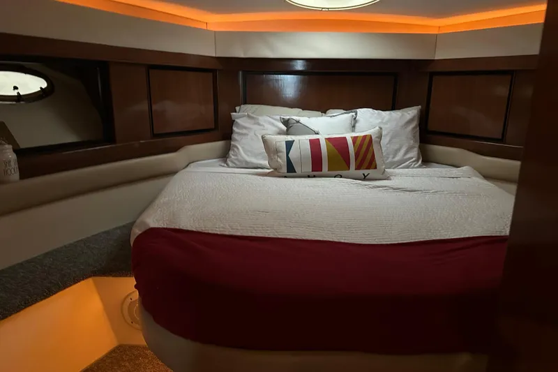Slide: The Image of Cozy cabin interior of 1998 Trojan 440 Express yacht with elegant bedding and ambient lighting. - 18