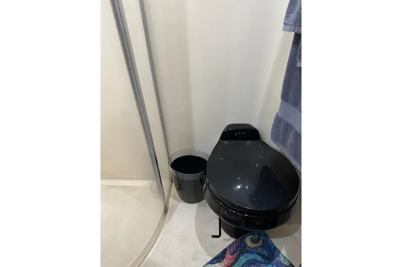 Slide: The Image of Compact bathroom in 1998 Trojan 440 Express yacht with black toilet and shower. - 21