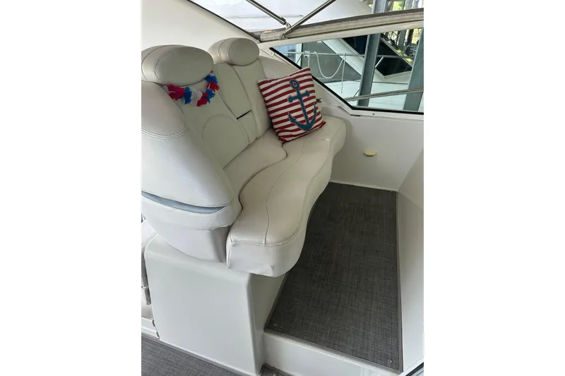 Slide: The Image of White leather seating with nautical-themed pillows on a 1998 Trojan 440 Express boat. - 27