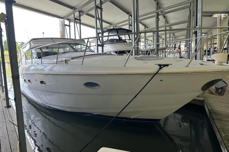 Slide: The Image of 1998 Trojan 440 Express yacht docked in a covered marina, showcasing sleek design and luxury. - 30