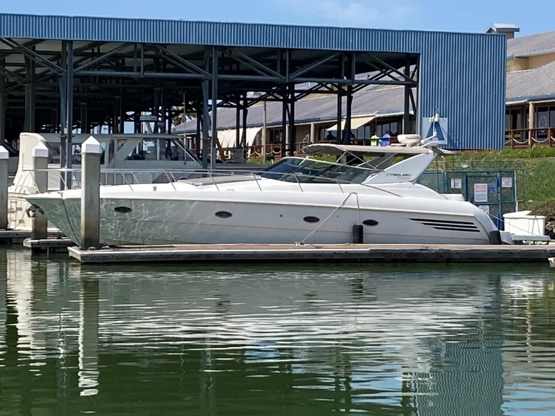 Slide: The Image of 1998 Trojan 440 Express yacht docked at marina, calm water reflections. - 32