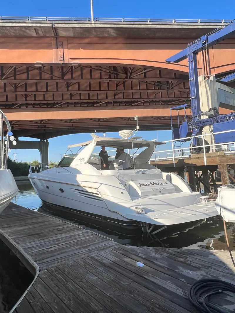 Slide: The Image of 1998 Trojan 440 Express yacht docked under a bridge on a sunny day. - 33
