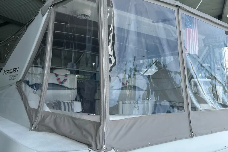 Slide: The Image of 1998 Trojan 440 Express yacht with clear enclosure and American flag. - 35