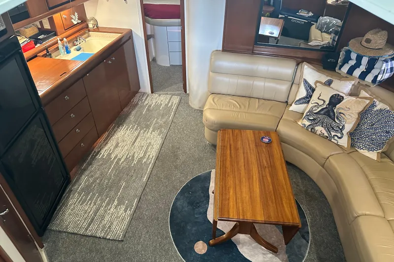 Slide: The Image of Interior of a 1998 Trojan 440 Express yacht with cozy seating and kitchenette. - 6