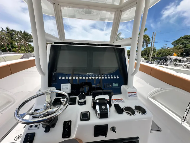 Slide: The Image of 2023 Twin Vee 340 GFX CC boat dashboard with steering wheel and control panel. - 12