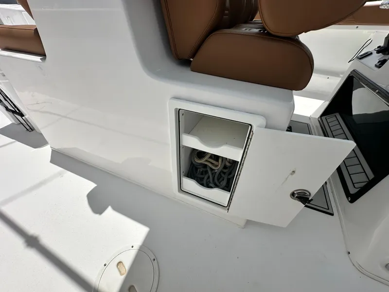 Slide: The Image of 2023 Twin Vee 340 GFX CC boat storage compartment with open door and visible ropes. - 18