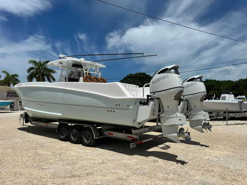 Slide: The Image of 2023 Twin Vee 340 GFX CC boat with dual Suzuki engines on a trailer. - 3