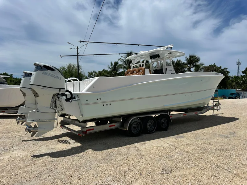 Slide: The Image of 2023 Twin Vee 340 GFX CC boat on trailer with dual Suzuki outboard motors. - 5