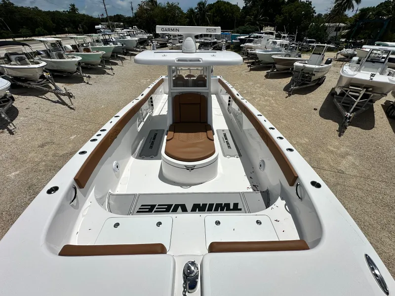 Slide: The Image of 2023 Twin Vee 340 GFX CC boat, white with brown accents, displayed among other boats. - 7