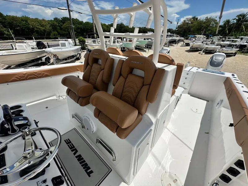 Slide: The Image of 2023 Twin Vee 340 GFX CC boat interior with tan seats and steering wheel. - 9