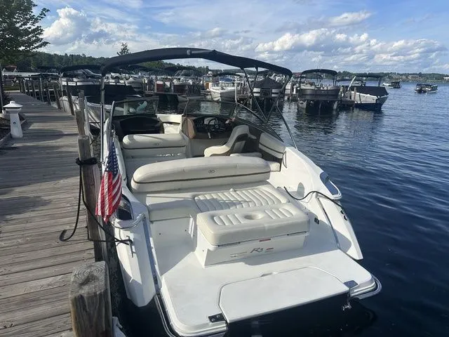 Slide: The Image of 2014 Cobalt R3 boat docked at a marina, featuring a spacious seating area and American flag. - 3