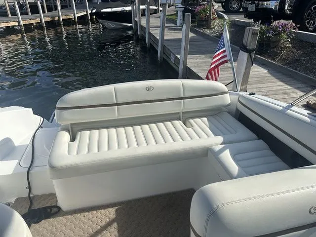Slide: The Image of 2014 Cobalt R3 boat with white seating, docked by a wooden pier, American flag visible. - 6