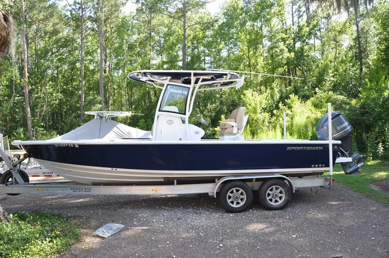 The Image of 2019 Sportsman Masters 267 Bay Boat on trailer, surrounded by lush greenery. - 1