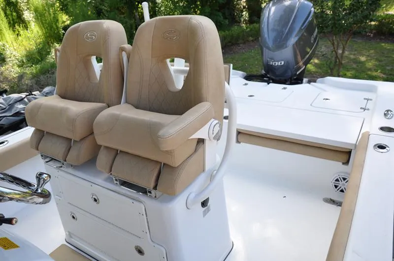 Slide: The Image of 2019 Sportsman Masters 267 Bay Boat with dual beige captain seats and powerful outboard motor. - 18