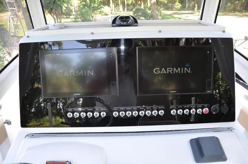 Slide: The Image of 2019 Sportsman Masters 267 Bay Boat dashboard with dual Garmin displays and control panel. - 20