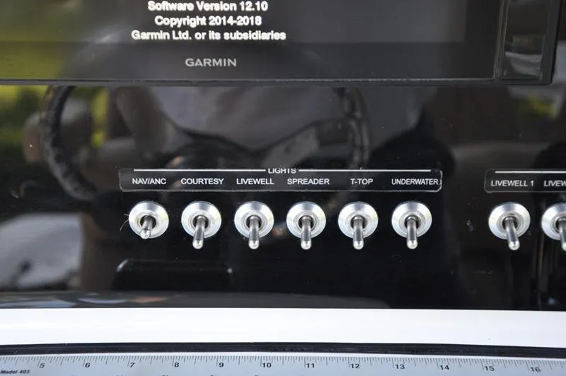 Slide: The Image of Control panel of a 2019 Sportsman Masters 267 Bay Boat with labeled switches. - 22