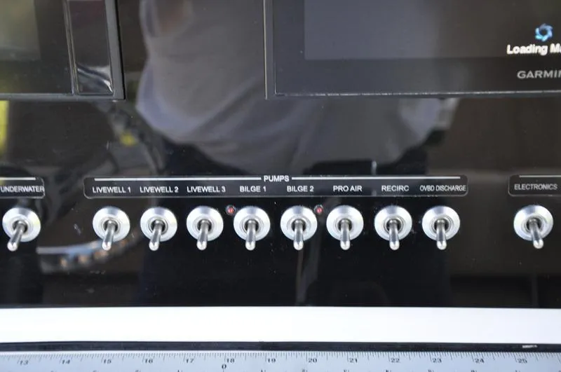 Slide: The Image of Control panel of a 2019 Sportsman Masters 267 Bay Boat with labeled switches. - 23
