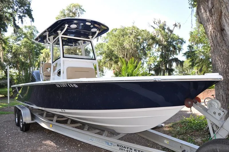 Slide: The Image of 2019 Sportsman Masters 267 Bay Boat on trailer, surrounded by lush greenery. - 4