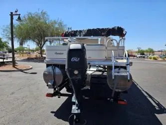 Slide: The Image of 2008 Sun Tracker Fishin' Barge 21 Signature pontoon boat with 60 HP motor, parked outdoors. - 2