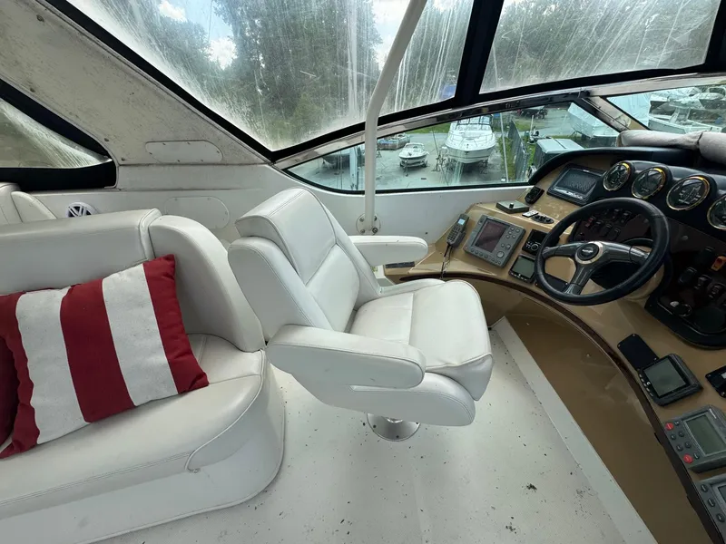 Slide: The Image of Pilothouse interior of 2003 Carver 570 Voyager with white seating and navigation controls. - 3