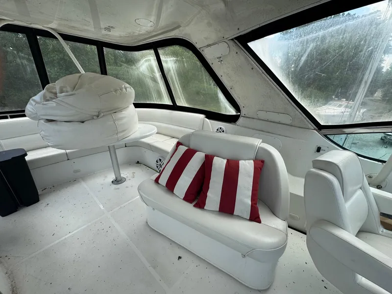 Slide: The Image of Interior of 2003 Carver 570 Voyager Pilothouse with white seating and striped cushions. - 4