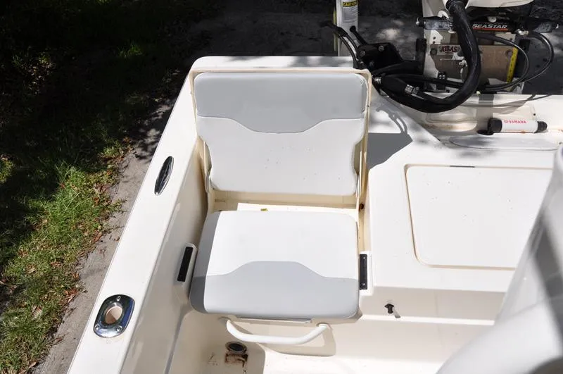 Slide: The Image of 2017 Skeeter SX 210 boat seat and steering area, featuring white cushioned seating. - 14