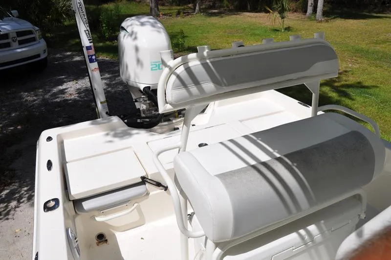 Slide: The Image of 2017 Skeeter SX 210 boat interior with seating and motor, parked outdoors. - 20