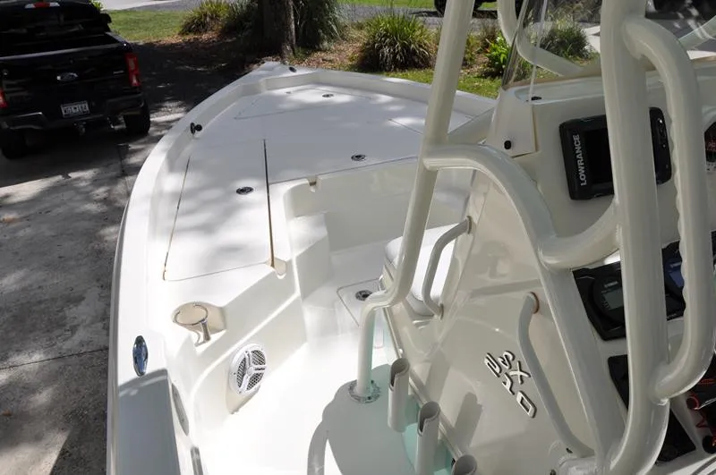 Slide: The Image of 2017 Skeeter SX 210 boat interior with console and seating, parked on a driveway. - 27