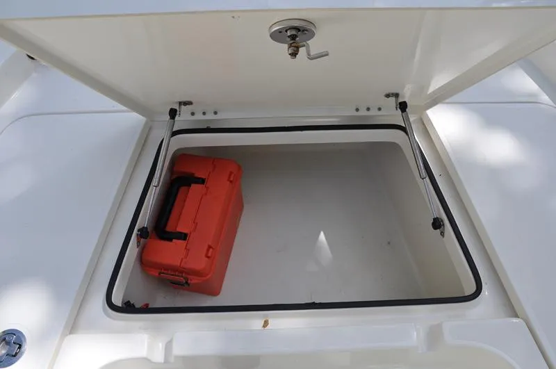 Slide: The Image of Open storage compartment on 2017 Skeeter SX 210 boat with orange toolbox inside. - 30