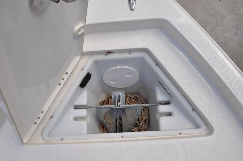 Slide: The Image of Anchor storage compartment on a 2017 Skeeter SX 210 boat, featuring rope and anchor. - 33