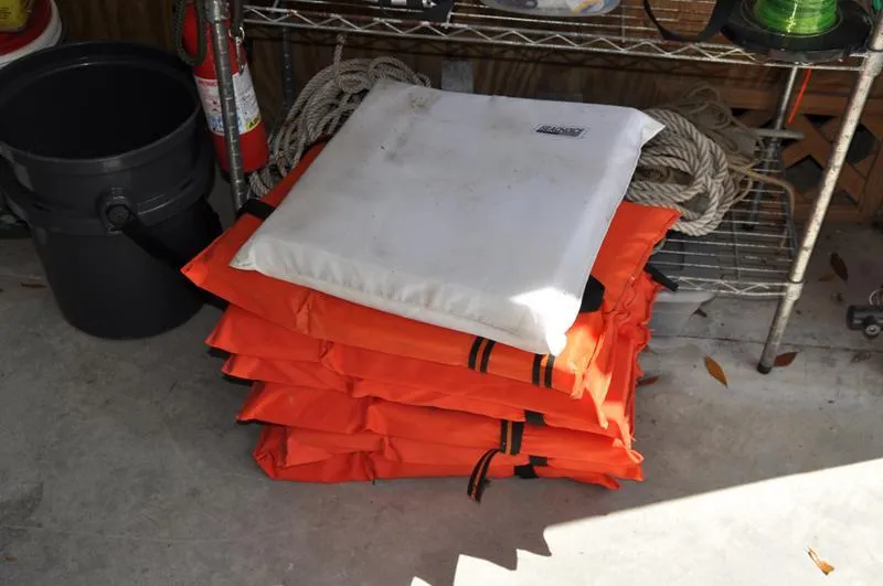 Slide: The Image of Stack of orange life jackets and a white cushion in a garage. - 36