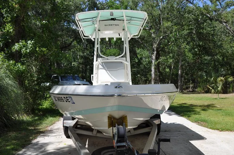 Slide: The Image of 2017 Skeeter SX 210 boat on trailer, parked in a wooded area. - 5