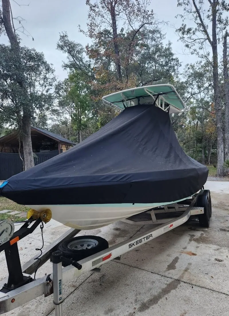 Slide: The Image of 2017 Skeeter SX 210 boat covered on trailer in wooded area. - 7