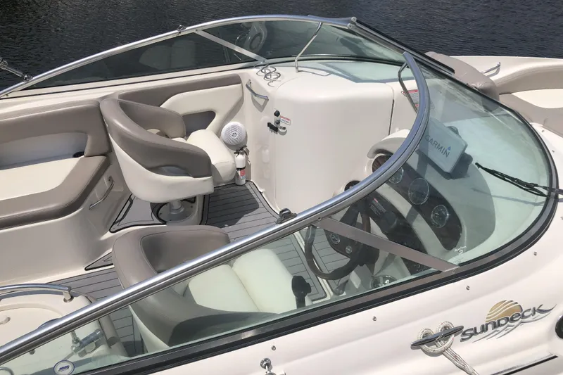 Slide: The Image of 2006 Sea Ray 270 Sundeck interior with steering wheel and seating, featuring Garmin navigation. - 11