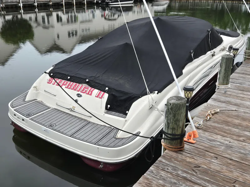Slide: The Image of 2006 Sea Ray 270 Sundeck boat docked with cover, reflecting on calm water. - 12