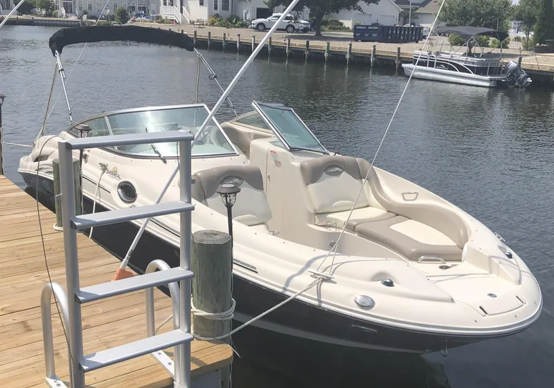 Slide: The Image of 2006 Sea Ray 270 Sundeck boat docked by a wooden pier on a sunny day. - 3