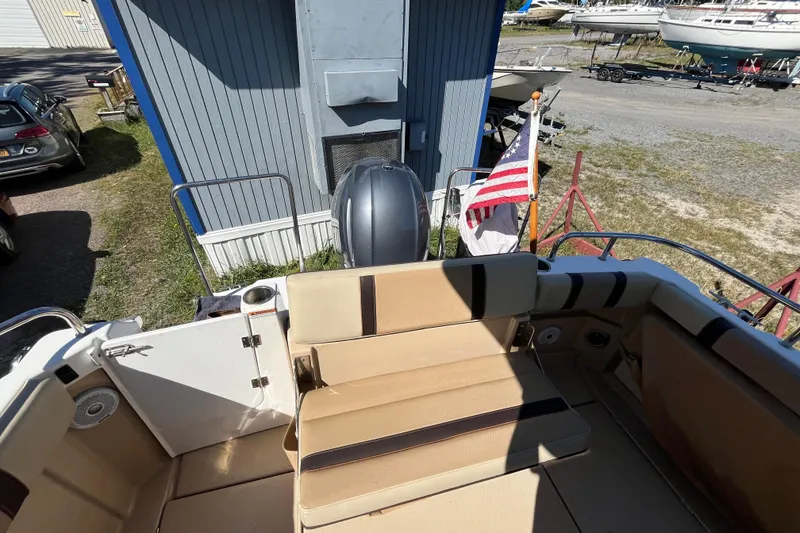 Slide: The Image of 2019 Ranger Tugs R-23 boat with American flag, docked near blue building. - 16