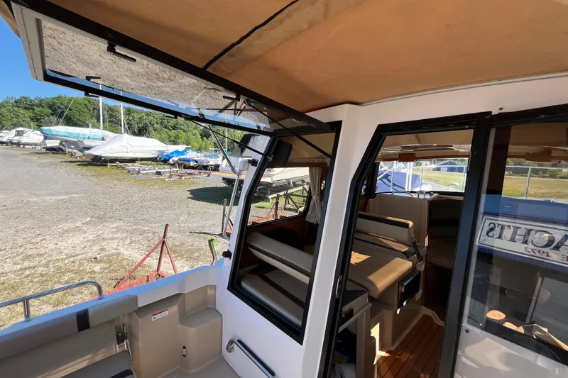 Slide: The Image of 2019 Ranger Tugs R-23 boat interior with open door, docked near other boats. - 18