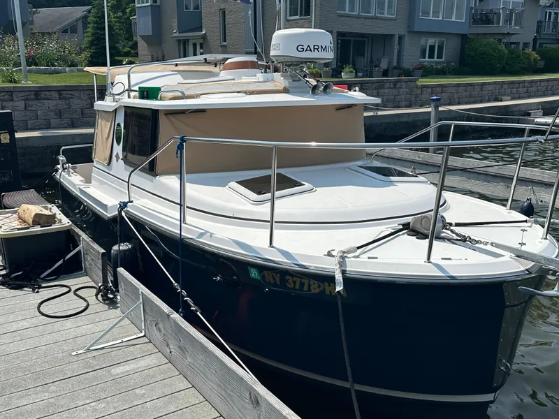 Slide: The Image of 2019 Ranger Tugs R-23 boat docked at a marina, featuring a Garmin radar. - 2