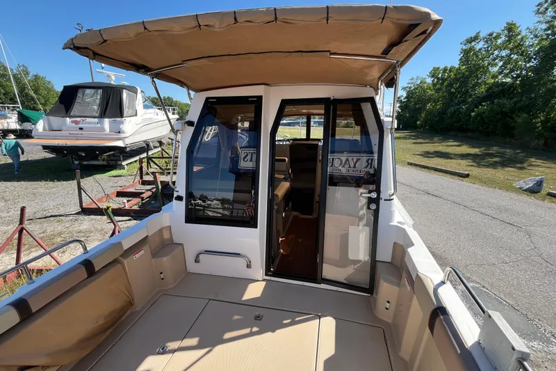 Slide: The Image of 2019 Ranger Tugs R-23 boat with open cockpit and canopy, docked outdoors. - 27