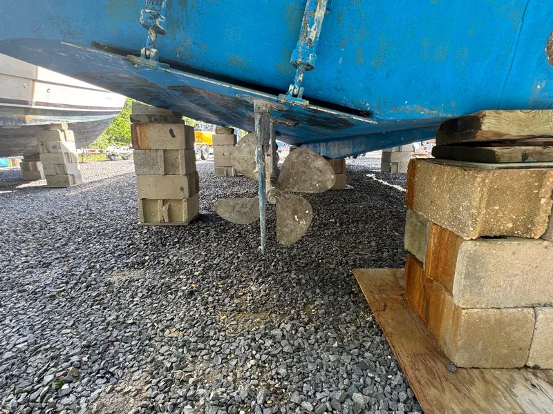 Slide: The Image of 1983 Viking 41 Convertible boat on blocks, showing propeller and hull. - 3