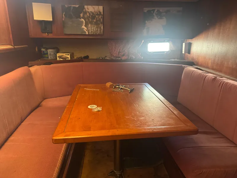 Slide: The Image of Cozy dining area inside a 1983 Viking 41 Convertible yacht with wooden table and cushioned seating. - 5