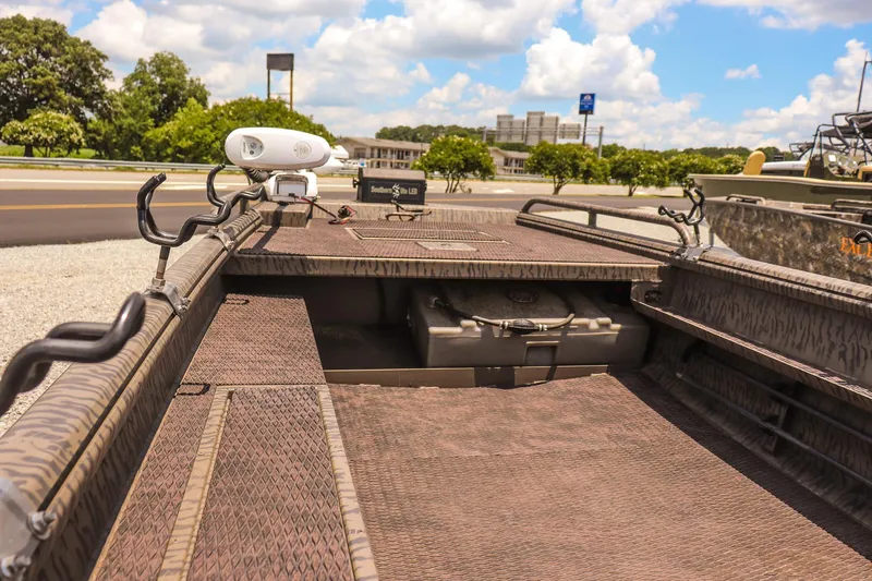 Slide: The Image of 2022 Gator Tail 1860 Extreme Mod V boat interior with storage and equipment, under a sunny sky. - 11