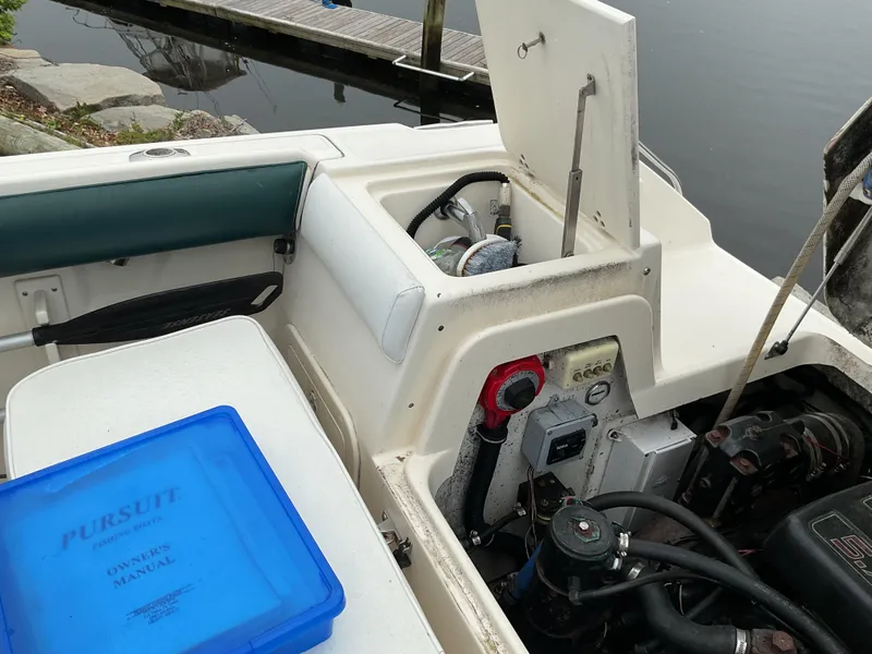 Slide: The Image of 1997 Pursuit 2460 Denali boat interior with engine compartment and owner's manual. - 3