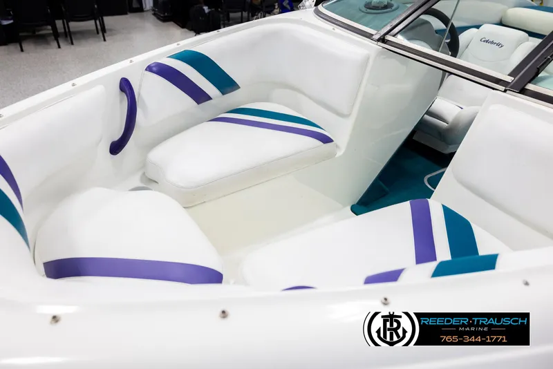 Slide: The Image of Interior of a 1997 Celebrity 190 boat with white and purple seating. - 10