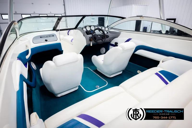 Slide: The Image of Interior of a 1997 Celebrity 190 boat with white and blue seating. - 11